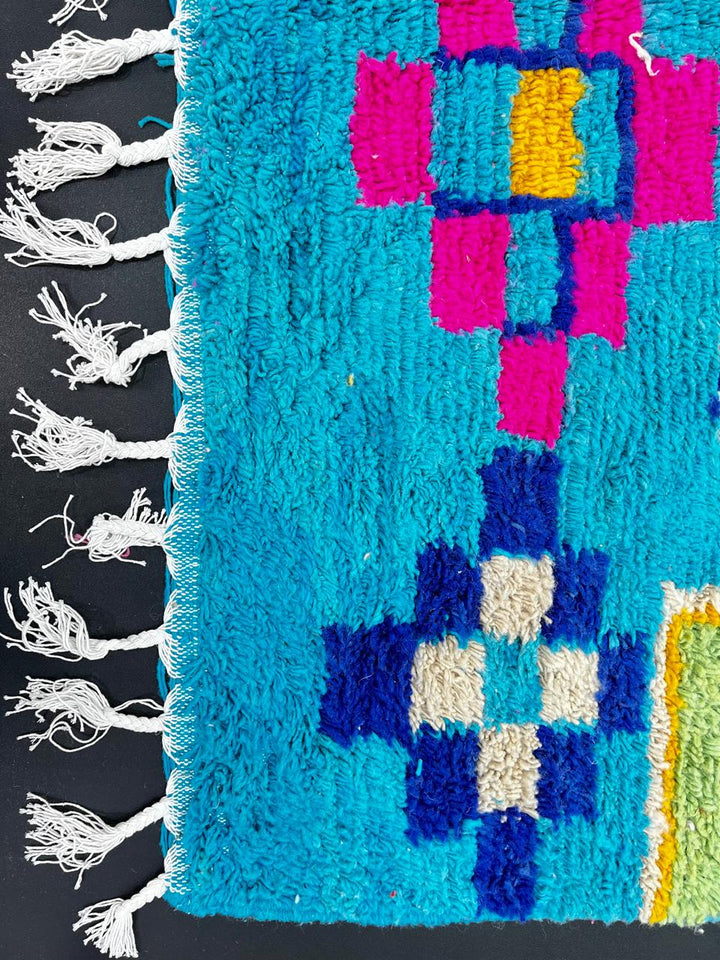 Handwoven blue Moroccan wool rug with colorful geometric Berber motifs