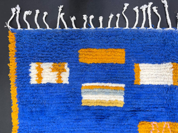Blue Moroccan wool rug with modern abstract Berber symbols on a plush handwoven surface