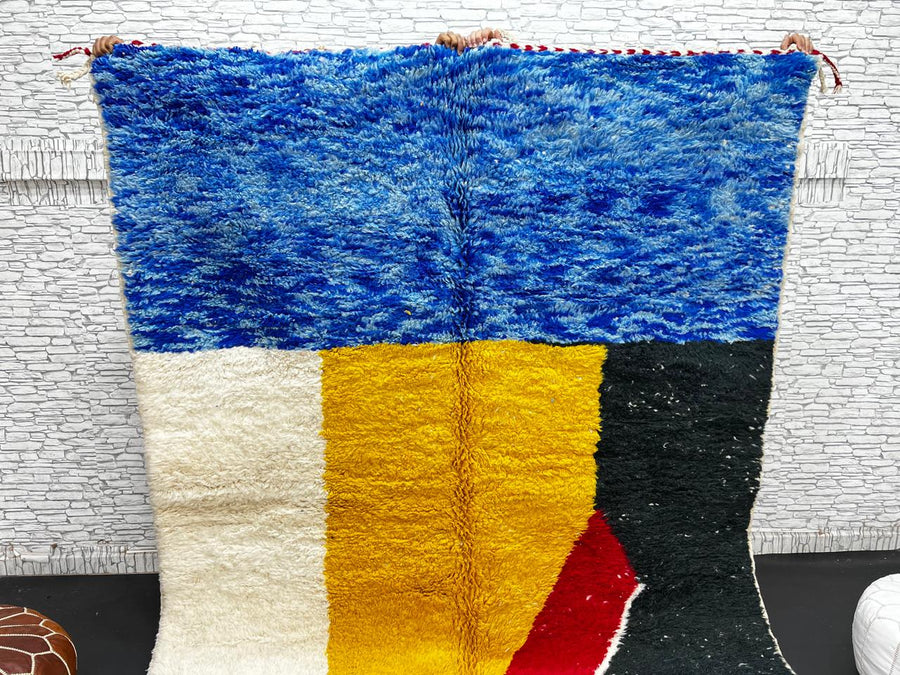 Handwoven Moroccan wool rug in blue, yellow, red, black, and white geometric pattern – modern Berber carpet handmade in Morocco
