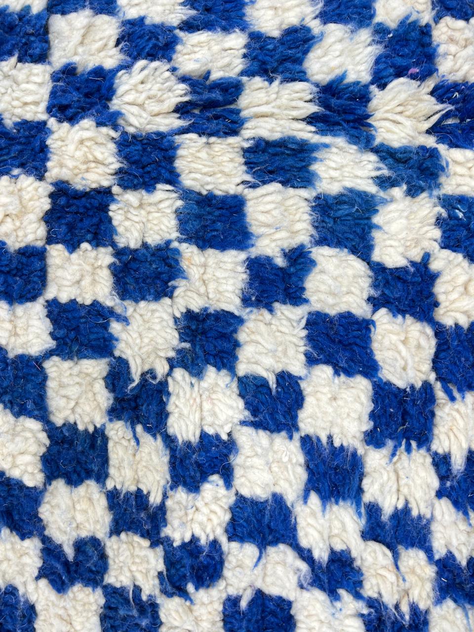 Round Moroccan wool rug with blue and white checkerboard pattern on a white background