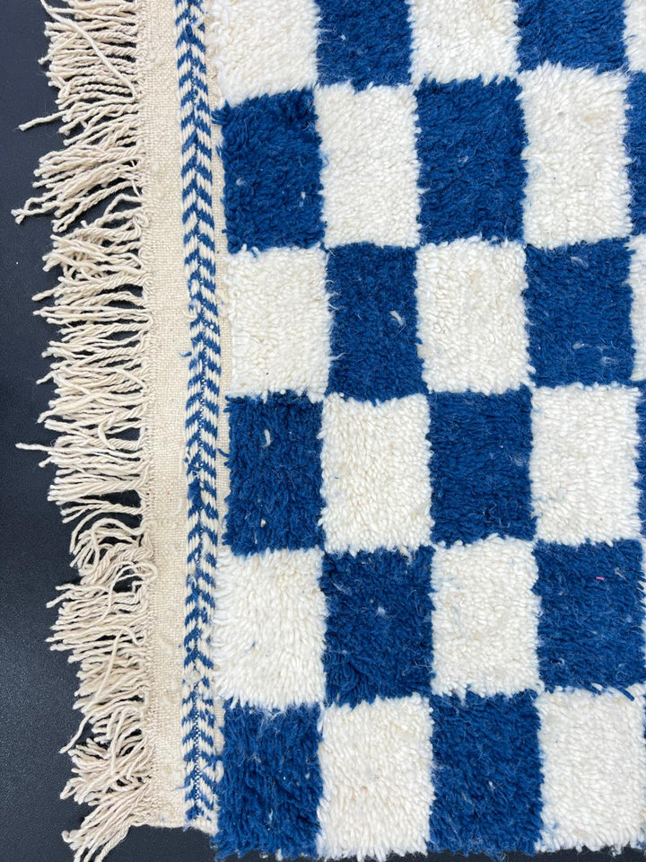 Handwoven blue and white Moroccan wool rug with checkerboard pattern