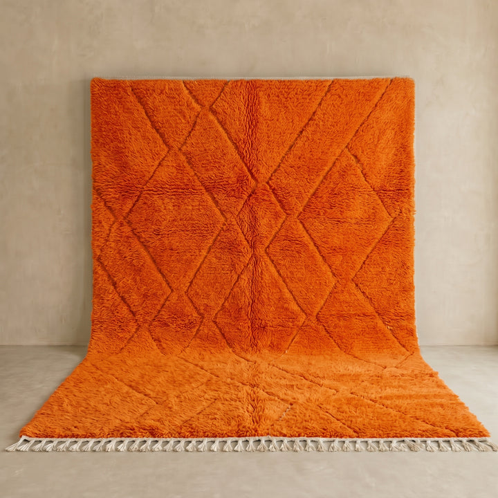 Handmade burnt orange Moroccan wool rug with diamond pattern and natural wool texture