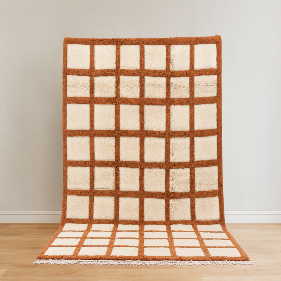 Rug with grid pattern on a wooden floor against a white wall
