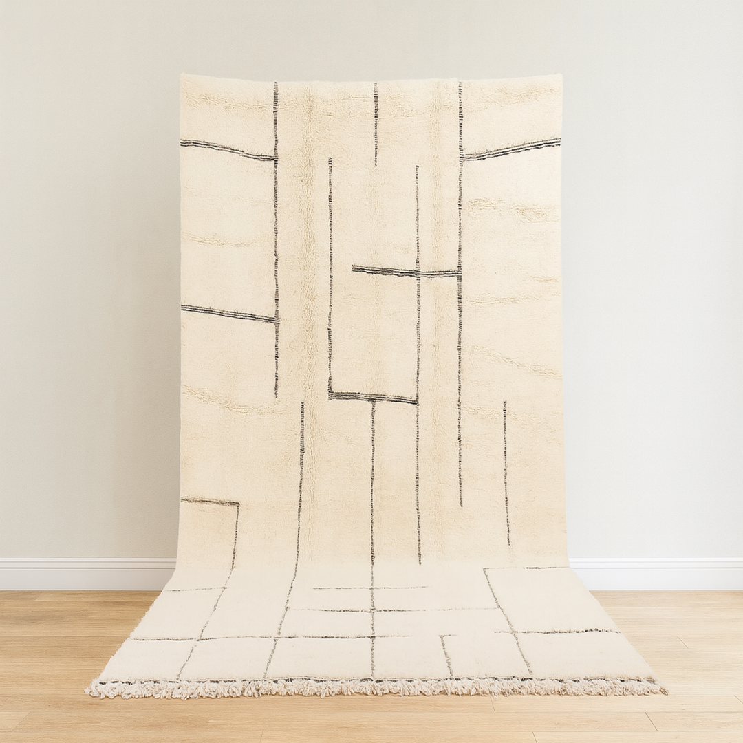 Beige rug with black geometric pattern on a wooden floor and light gray wall background
