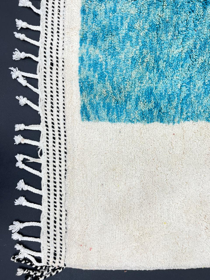 Handwoven Moroccan wool rug with bold geometric color blocks in blue, yellow, and red