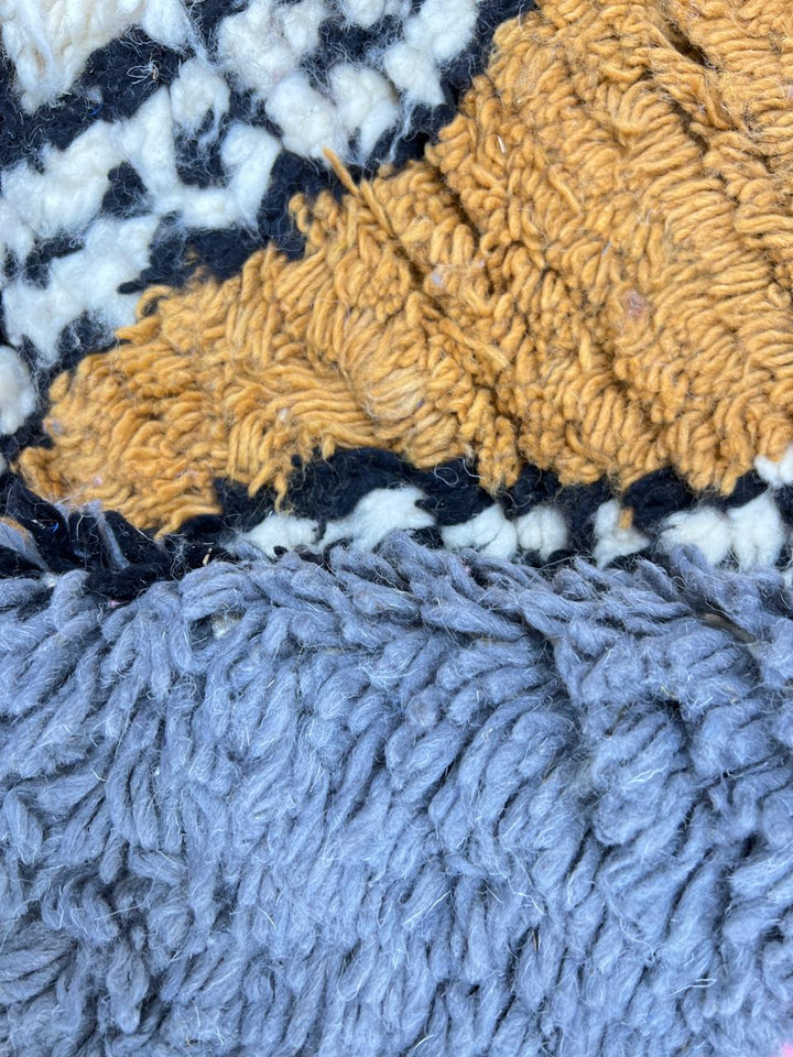 Colorful Moroccan wool runner rug with abstract artistic design in blue, pink, mustard, beige, and black tones