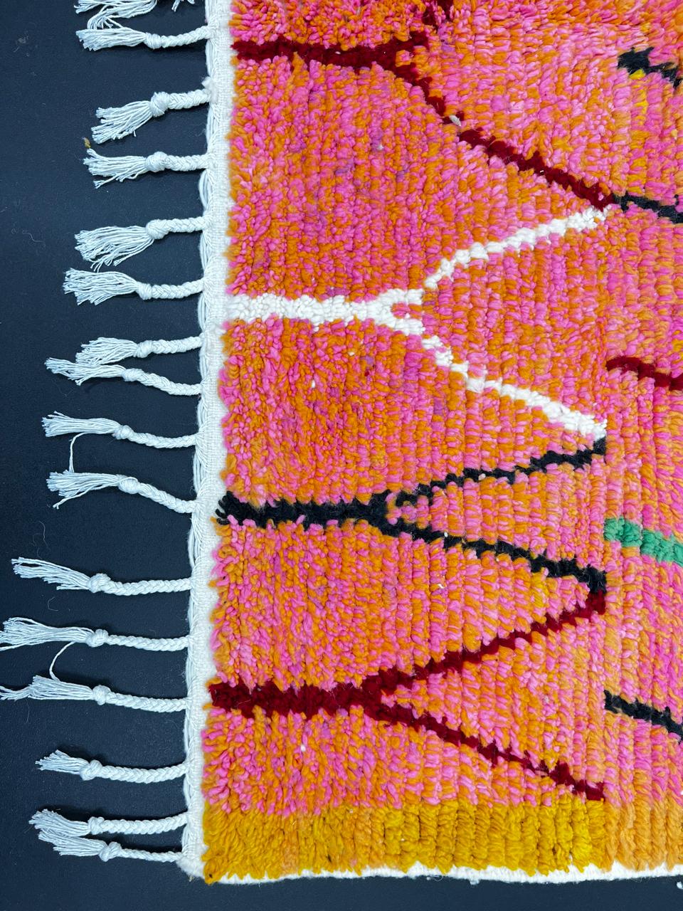 Handmade colorful Moroccan runner rug with abstract geometric design in orange, pink, green, and earthy tones, crafted from natural wool by Berber artisans.