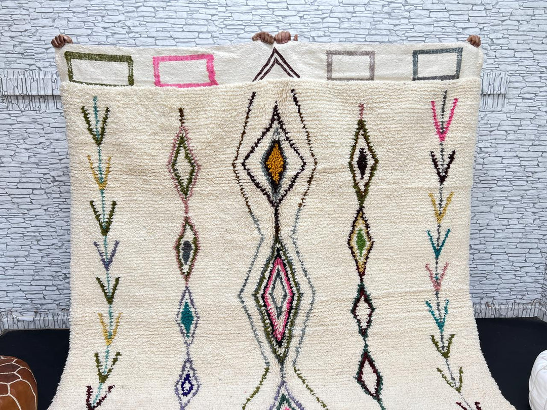 Handmade Moroccan Beni Ourain wool rug with colorful geometric diamond patterns on ivory background