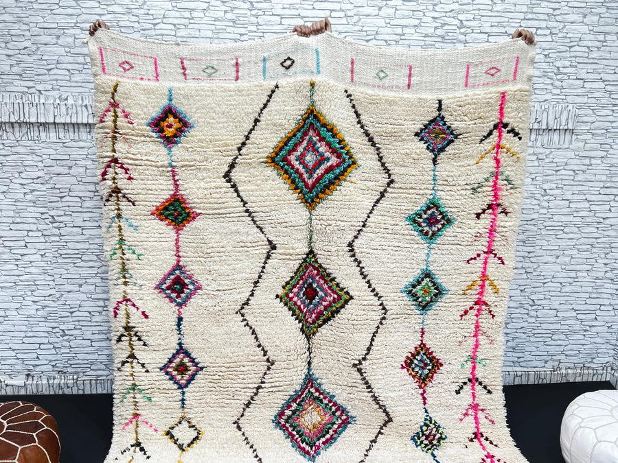 Colorful Beni Ourain Moroccan wool rug with diamond tribal patterns in pink, turquoise, and green on ivory background