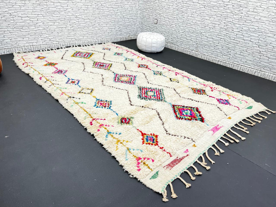 Colorful Beni Ourain Moroccan wool rug with diamond tribal patterns in pink, turquoise, and green on ivory background