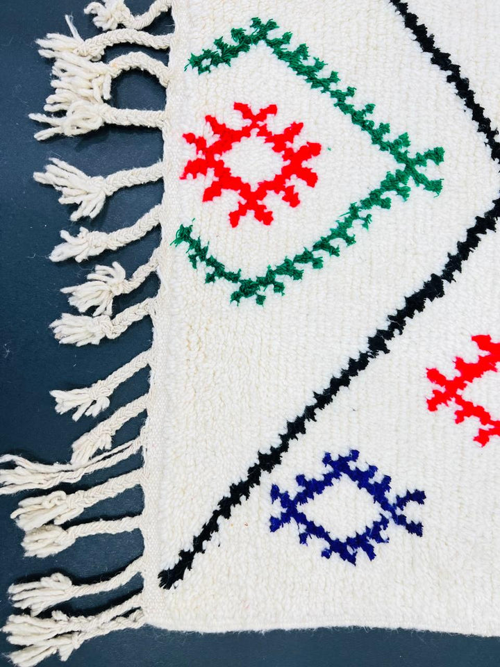 Colorful Berber Moroccan runner rug with diamond pattern and multicolor tribal symbols on cream wool background