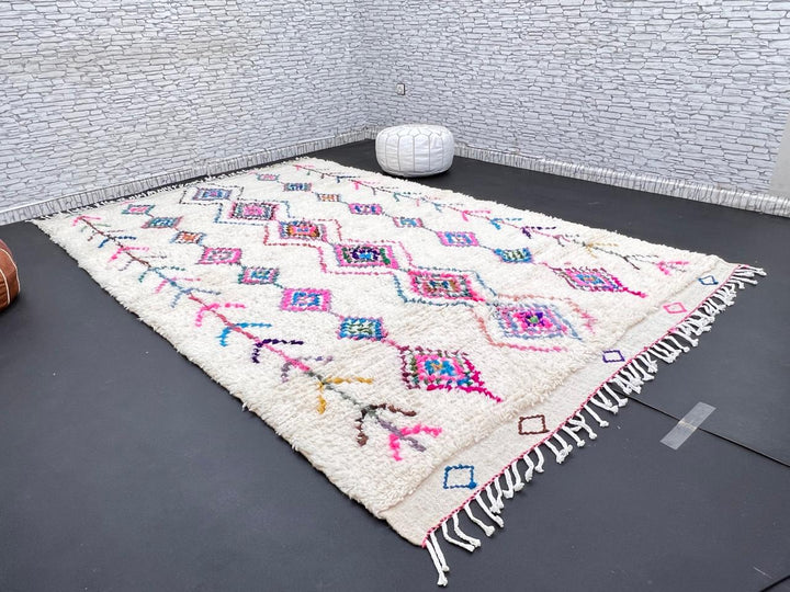 Colorful handmade Moroccan Berber rug with diamond tribal patterns on white wool