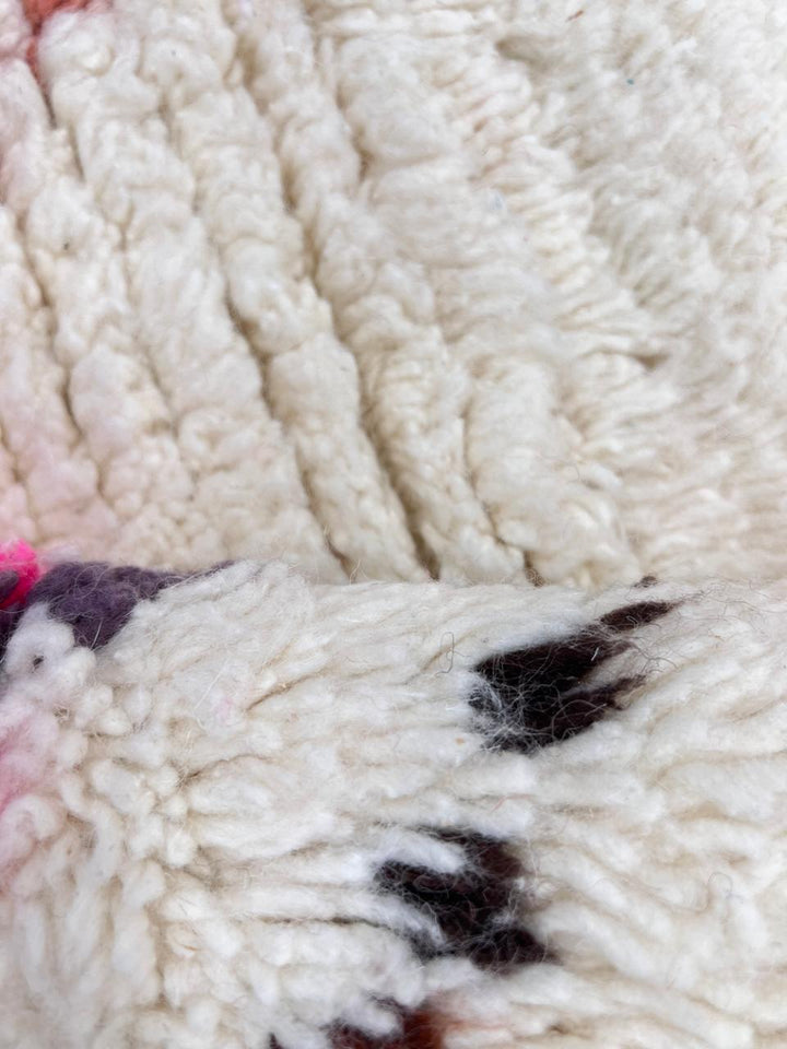 Colorful handmade Moroccan Berber rug with diamond tribal patterns on white wool