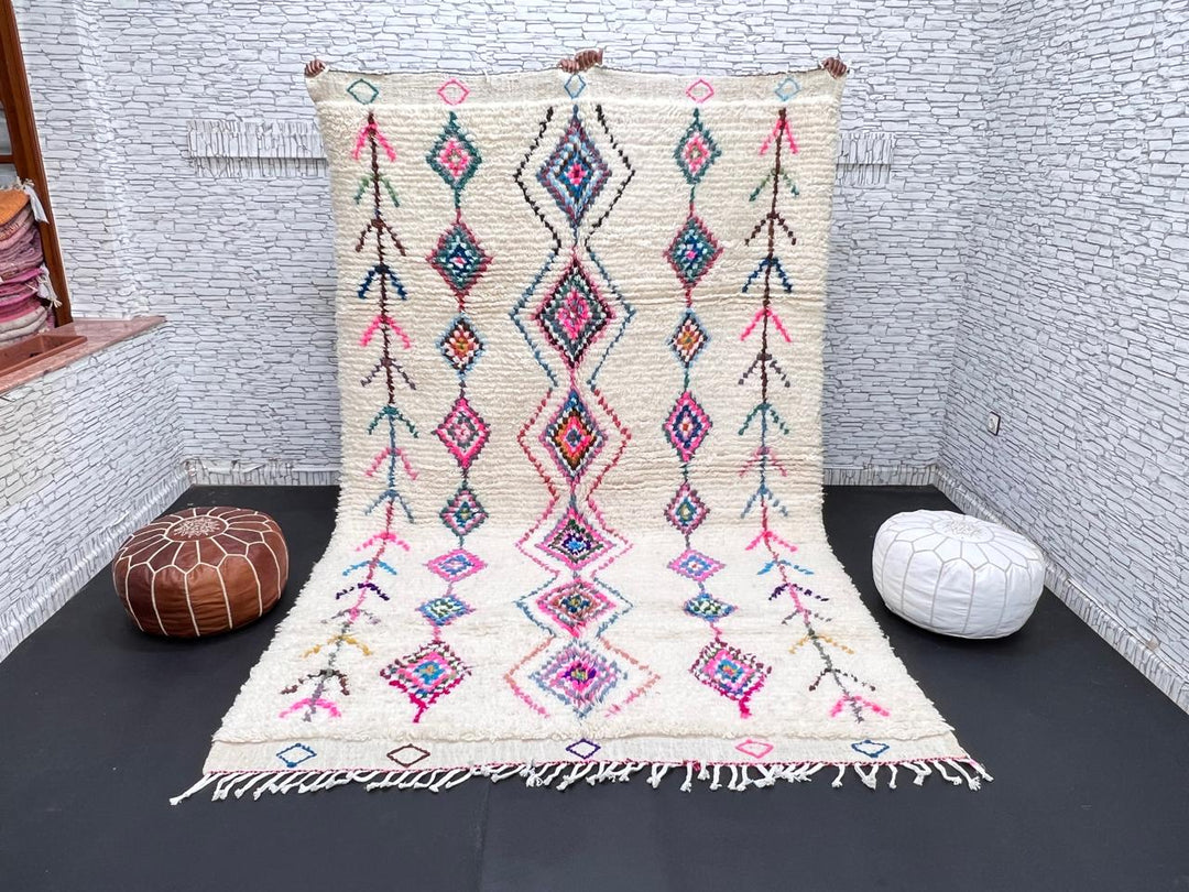 Colorful handmade Moroccan Berber rug with diamond tribal patterns on white wool