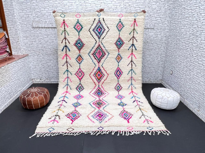 Colorful handmade Moroccan Berber rug with diamond tribal patterns on white wool