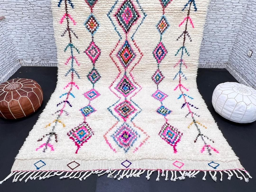 Colorful handmade Moroccan Berber rug with diamond tribal patterns on white wool
