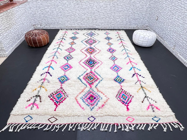 Colorful handmade Moroccan Berber rug with diamond tribal patterns on white wool