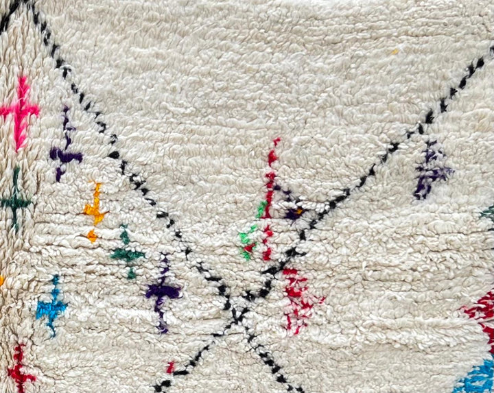 Handmade ivory Moroccan wool runner rug with colorful Berber motifs inside black diamond Beni Ourain pattern