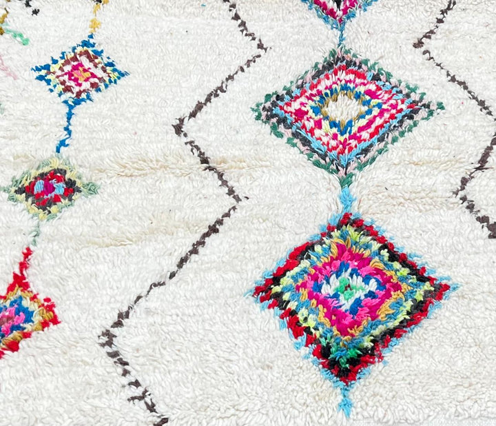 Handmade Moroccan wool runner rug with colorful Berber diamond motifs on a white background