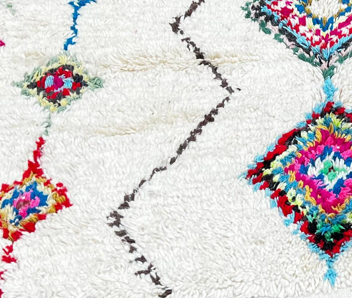 Handmade Moroccan wool runner rug with colorful Berber diamond motifs on a white background