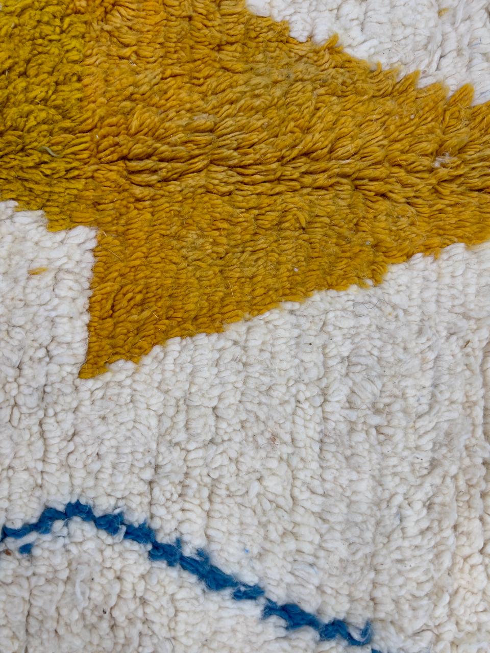 Handwoven Moroccan wool rug with colorful diamond geometric design on ivory background