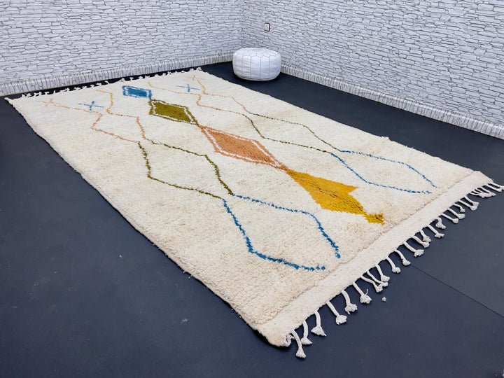 Handwoven Moroccan wool rug with colorful diamond geometric design on ivory background