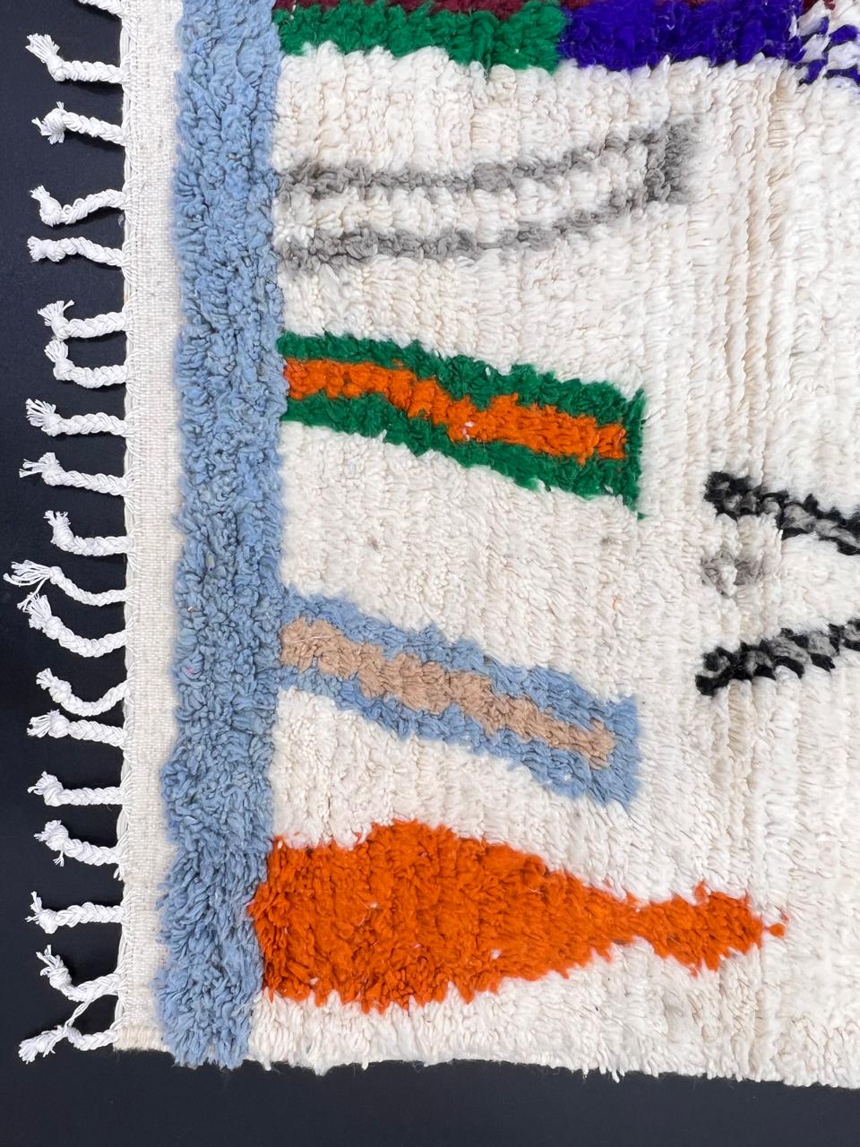 colorful handmade moroccan berber rug with geometric patterns on ivory wool background