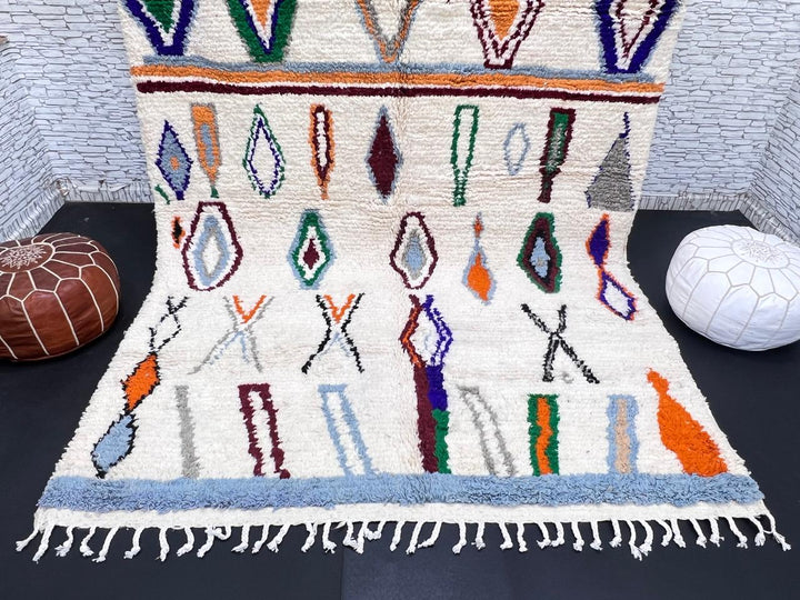 colorful handmade moroccan berber rug with geometric patterns on ivory wool background