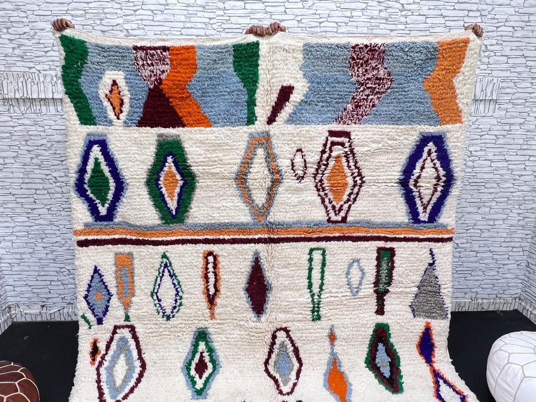 colorful handmade moroccan berber rug with geometric patterns on ivory wool background