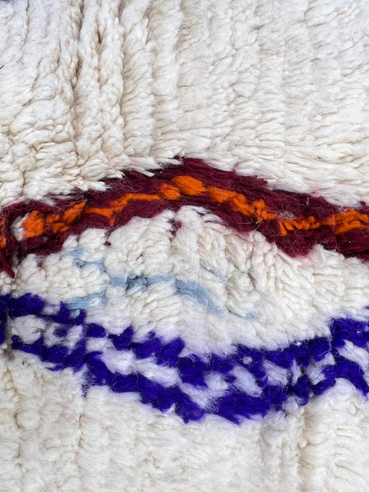 colorful handmade moroccan berber rug with geometric patterns on ivory wool background