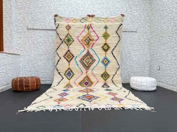 Colorful handmade Moroccan Berber wool rug with vibrant diamond patterns on ivory background