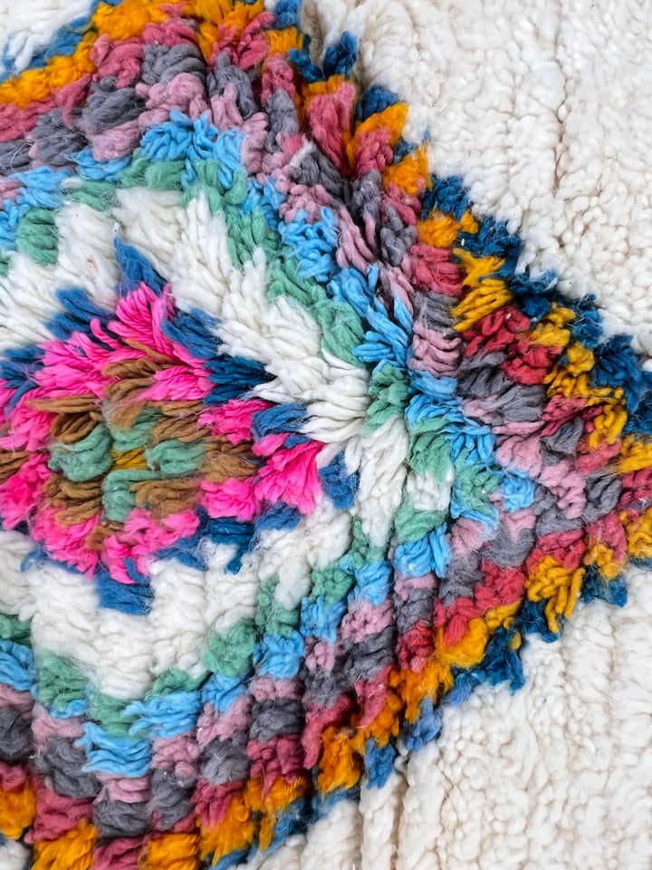 Handmade Moroccan Berber rug with colorful diamond patterns on white wool