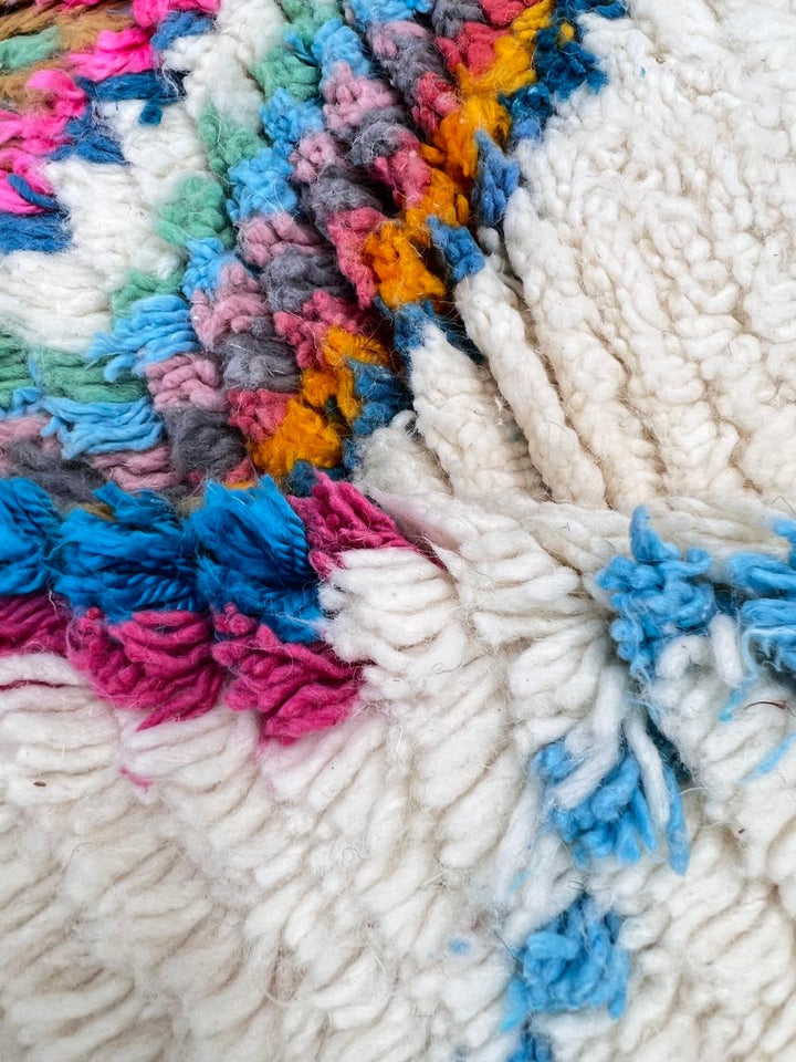Handmade Moroccan Berber rug with colorful diamond patterns on white wool