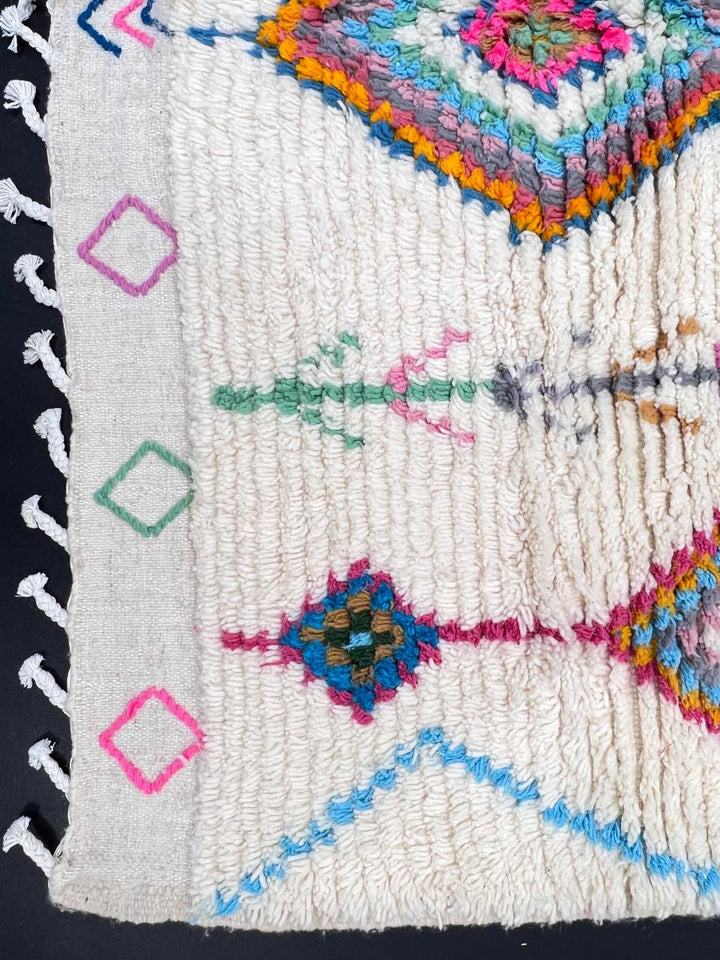 Handmade Moroccan Berber rug with colorful diamond patterns on white wool