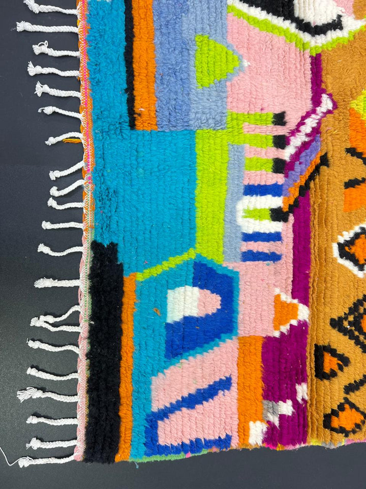 Colorful abstract Moroccan runner rug handwoven in wool with pink, orange, yellow and blue geometric patterns