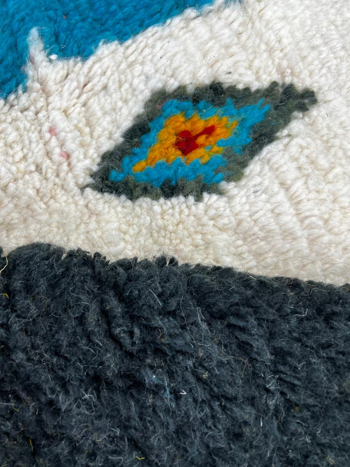 Handmade colorful Moroccan runner rug with patchwork blocks in burgundy, teal, mustard, cream, black, and turquoise featuring diamond Berber motifs.