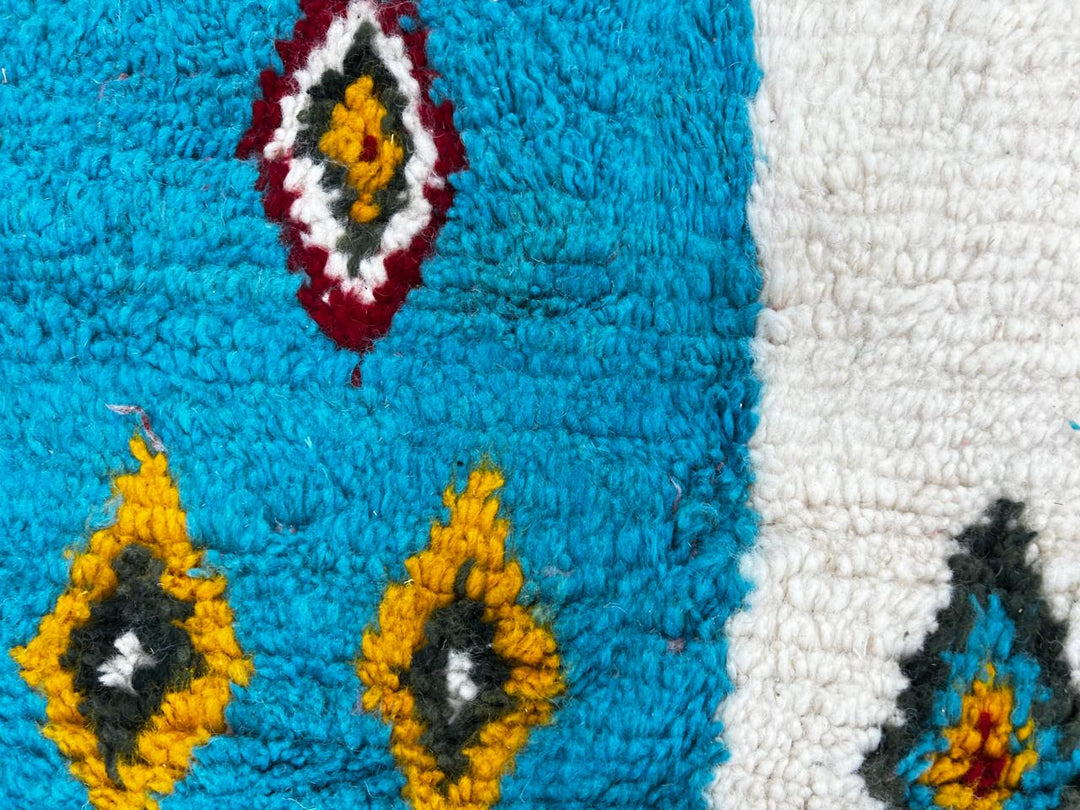 Handmade colorful Moroccan runner rug with patchwork blocks in burgundy, teal, mustard, cream, black, and turquoise featuring diamond Berber motifs.