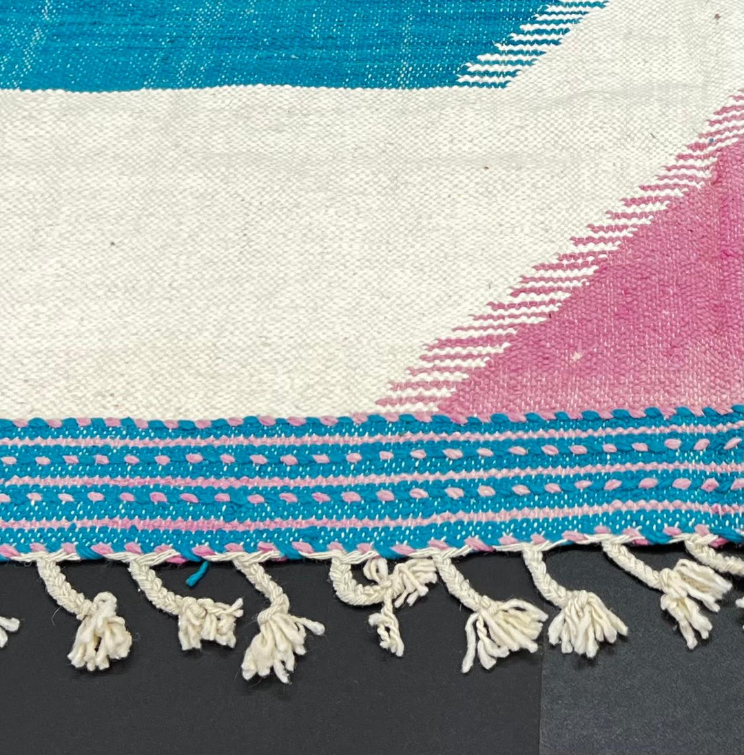 Handmade Moroccan runner rug with pink and blue geometric design, white accents and flatwoven kilim texture