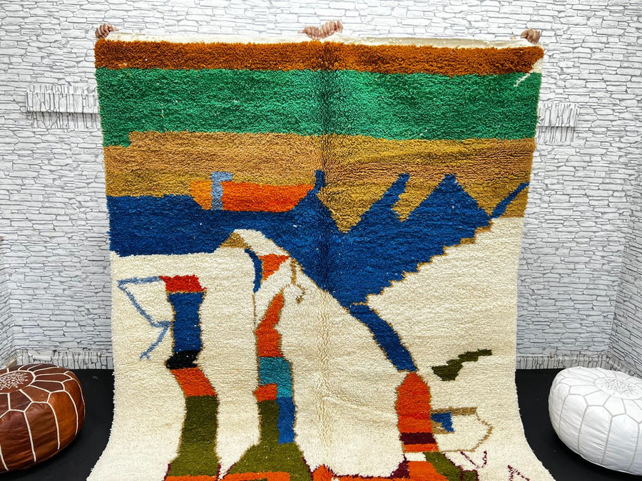 Colorful Moroccan wool rug with abstract desert and mountain design, handmade by Berber artisans