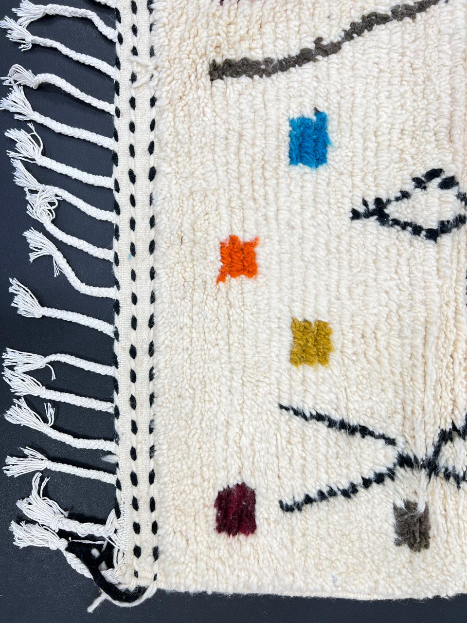 Handwoven Moroccan wool rug with multicolor geometric motifs on an ivory background, colorful Berber rug