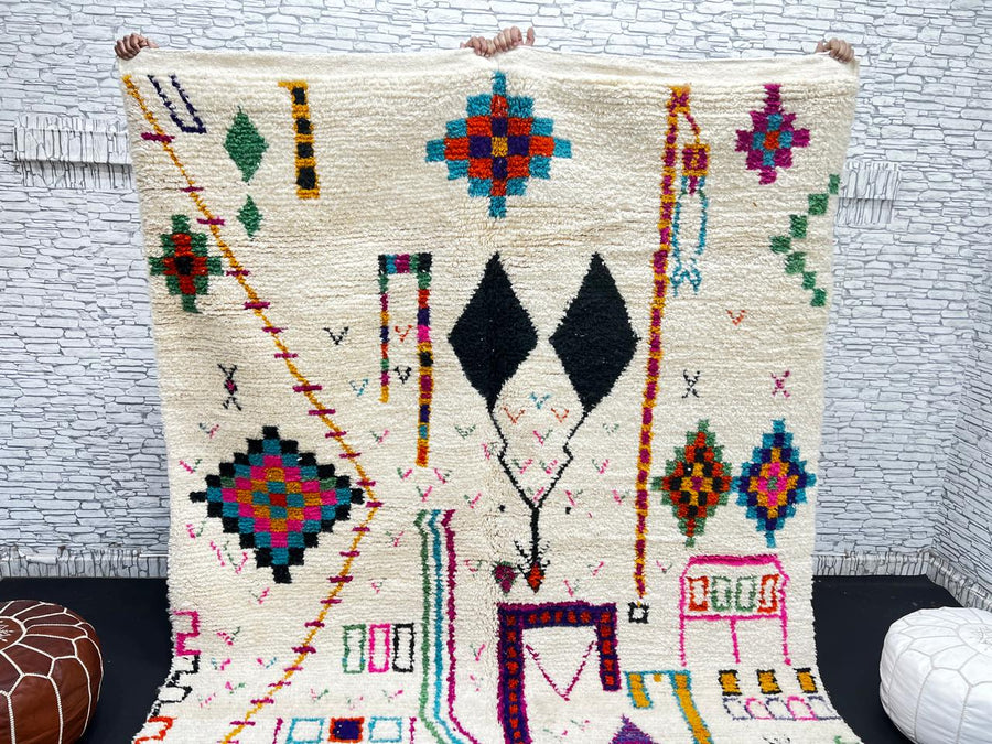 Handwoven colorful Moroccan wool rug with geometric Berber motifs on ivory background