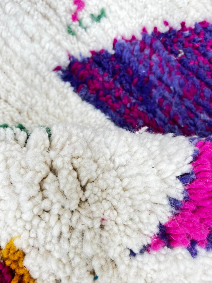 Handwoven colorful Moroccan wool rug with geometric Berber motifs on ivory background