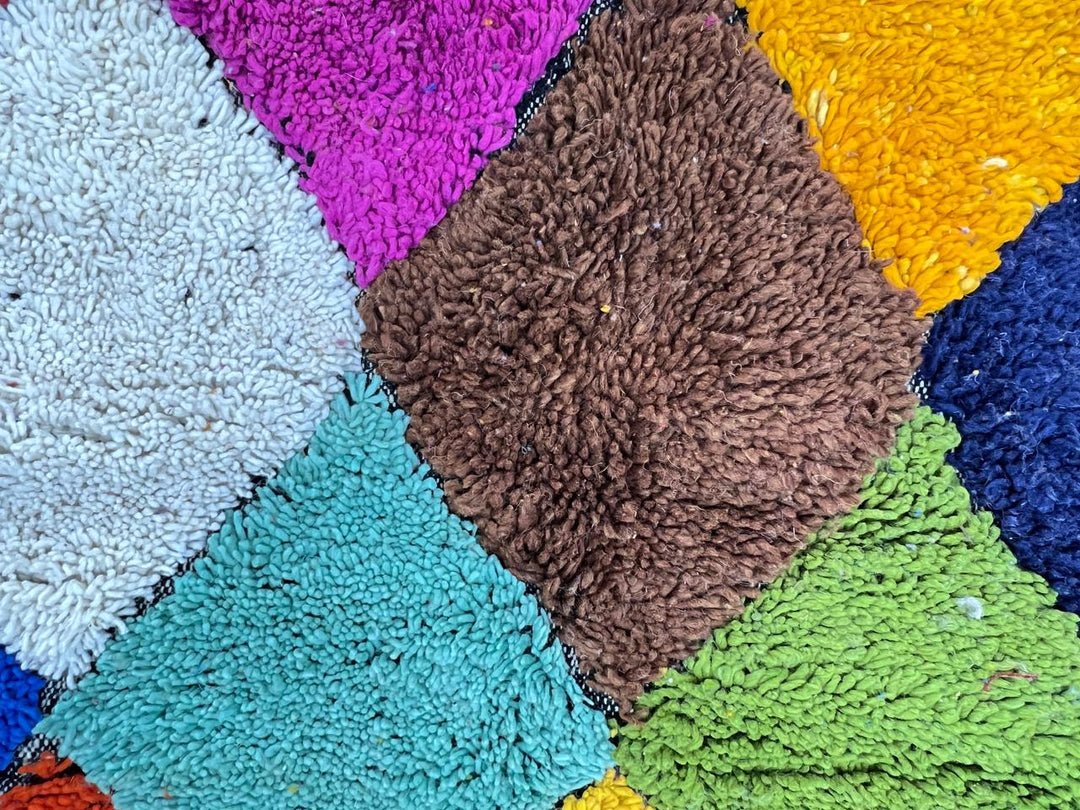 Round handmade Moroccan Berber rug with colorful checkerboard diamond pattern in multicolor wool.