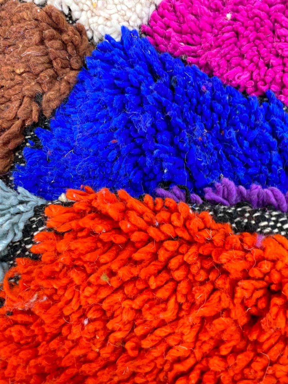 Round handmade Moroccan Berber rug with colorful checkerboard diamond pattern in multicolor wool.