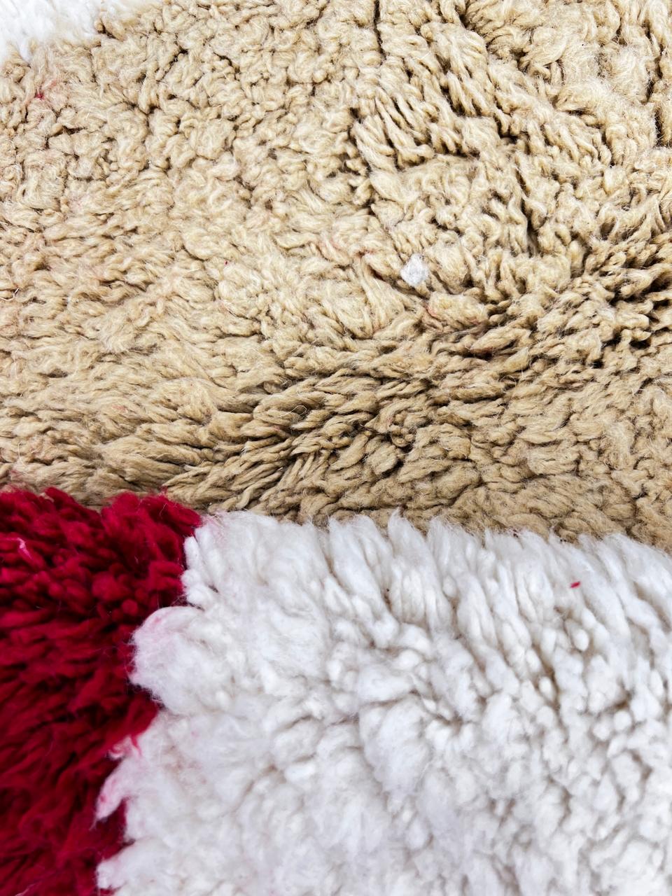 Colorful round Moroccan wool rug with handmade Berber design on white background.