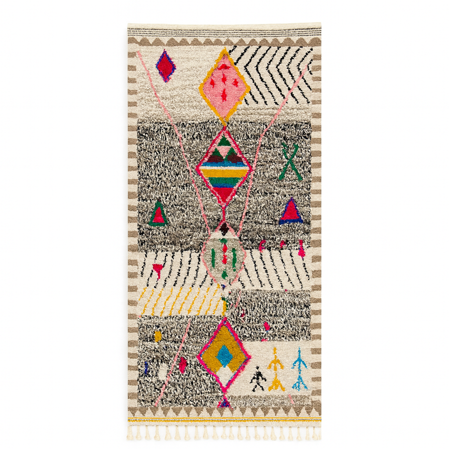 Handmade colorful Moroccan wool runner rug with geometric tribal patterns in pink, yellow, blue, green, and black on a white base.