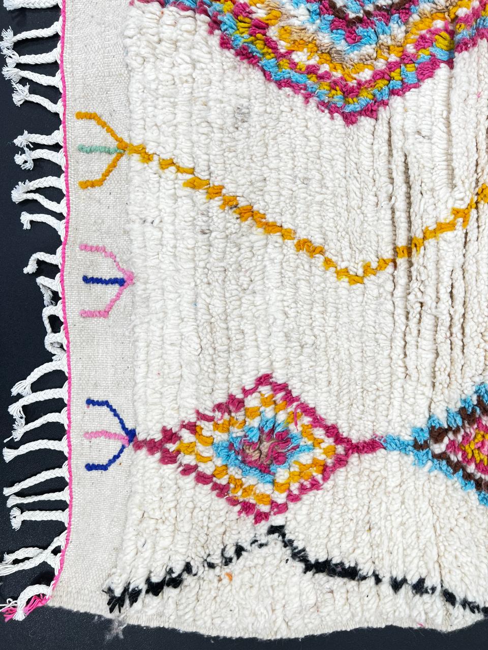 Handmade Moroccan runner rug with colorful diamond patterns on a white  background, crafted from natural wool by Berber artisans.