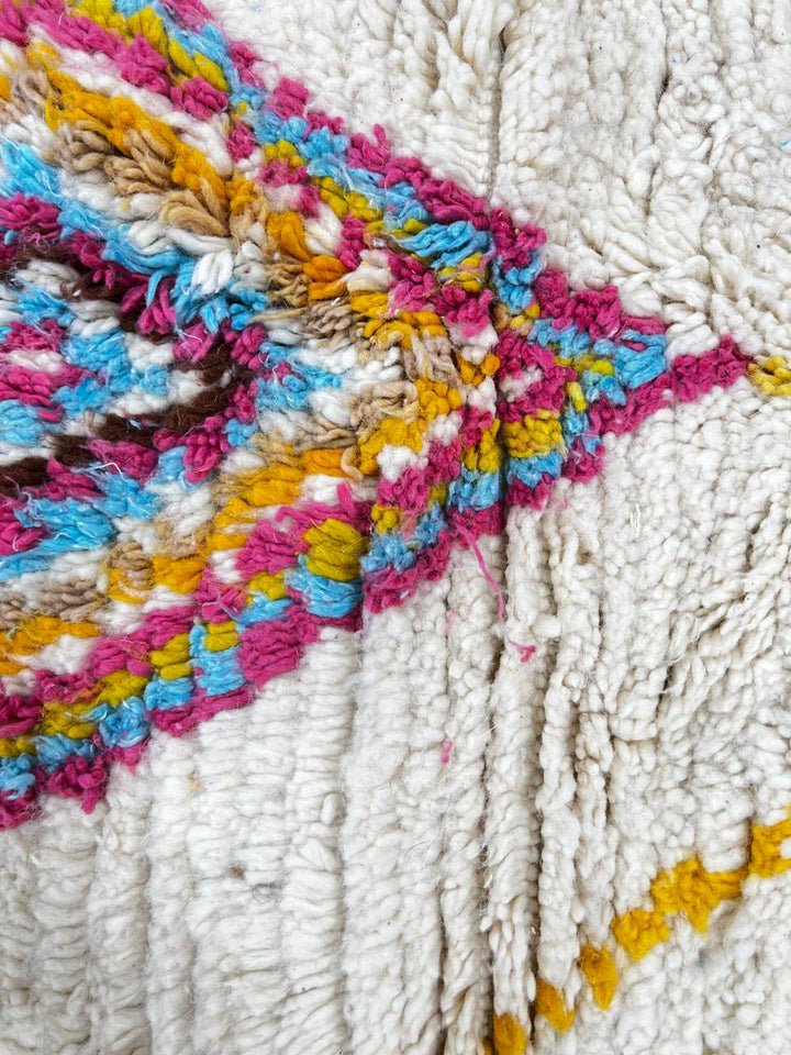 Handmade Moroccan runner rug with colorful diamond patterns on a white  background, crafted from natural wool by Berber artisans.