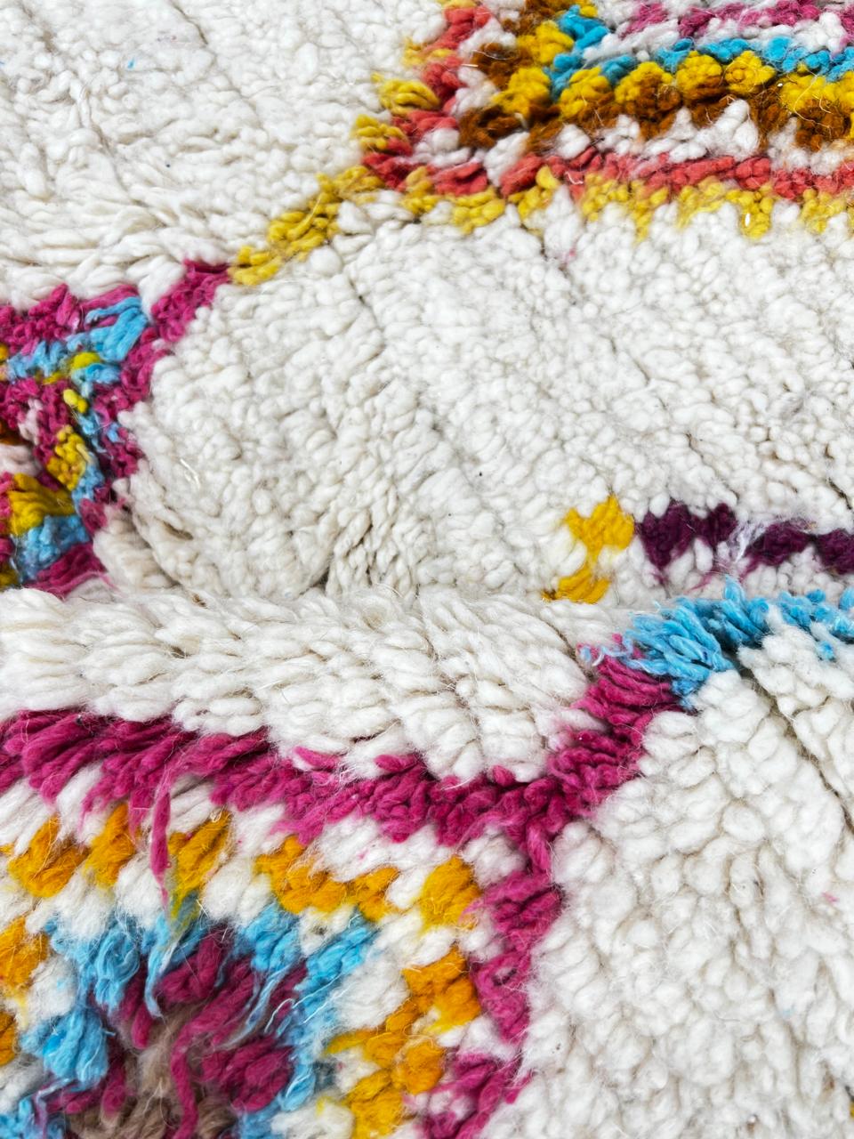 Handmade Moroccan runner rug with colorful diamond patterns on a white  background, crafted from natural wool by Berber artisans.