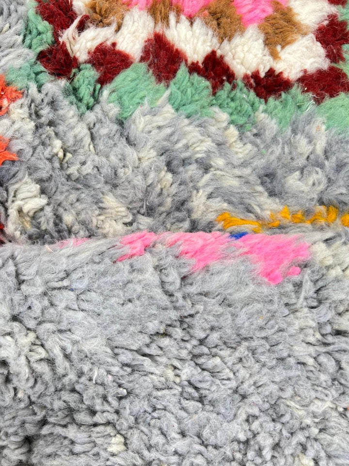 Colorful Moroccan wool runner rug with multicolor diamond patterns on a gray background